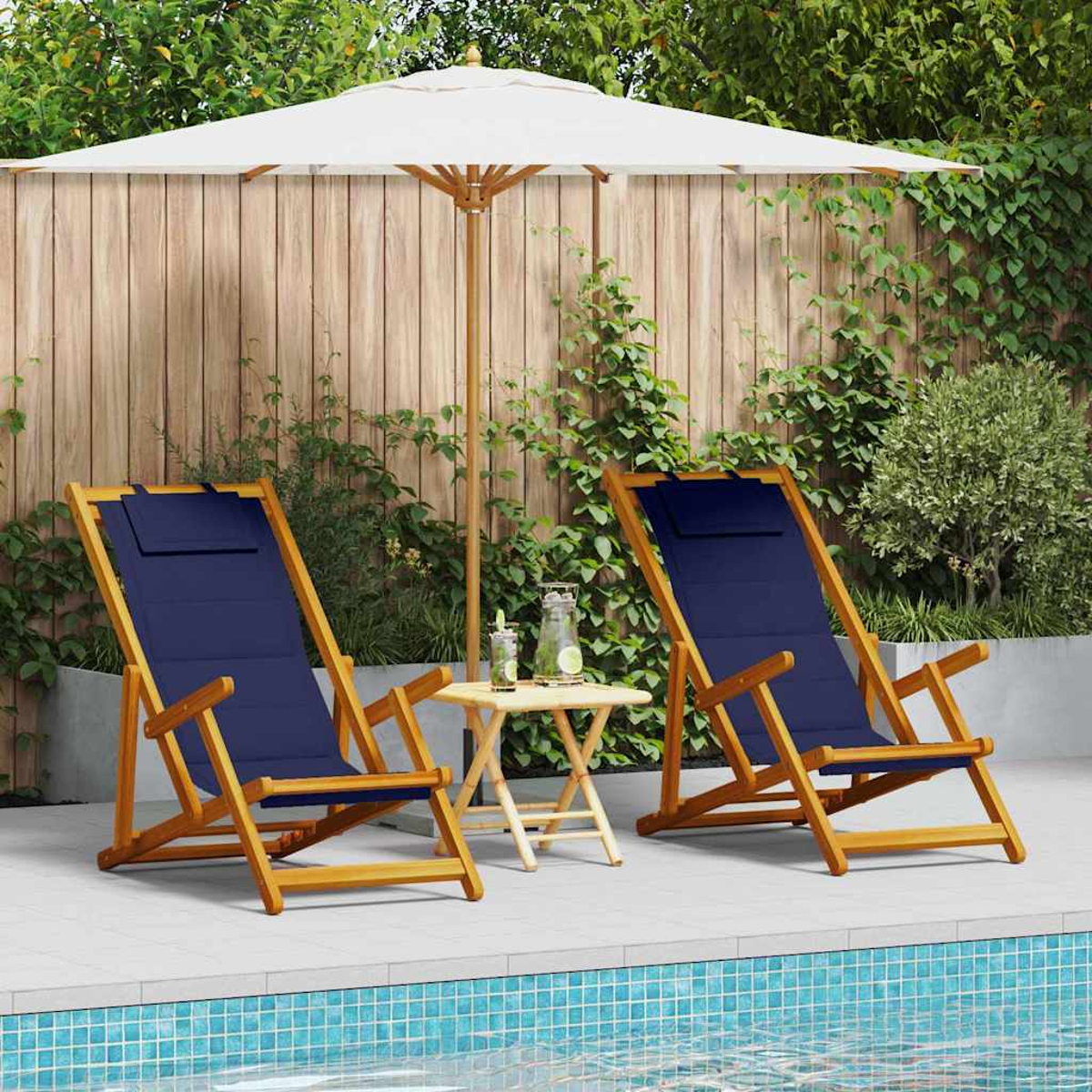 Zwei blaue Holzliegen stehen am Pool. Ein kleiner Tisch mit Getränken steht zwischen ihnen, unter einem großen weißen Sonnenschirm.