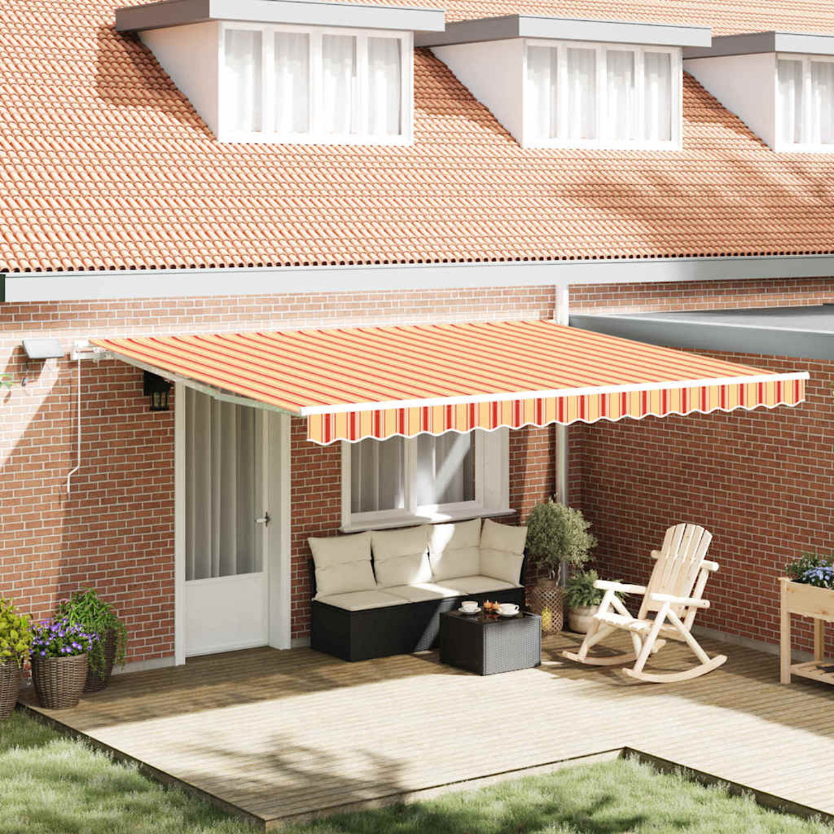 Eine Terrasse mit orangefarbener gestreifter Markise, Sitzbereich und Schaukelstuhl. Rote Backsteinmauer, Holzterrasse und grünes Gras im Vordergrund.