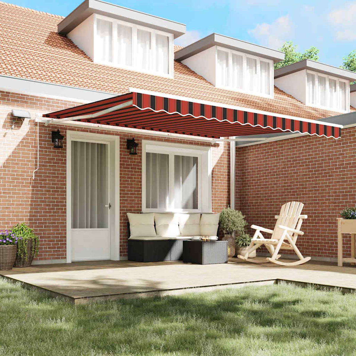 Ein Haus mit rot gestreifter Markise über einer Terrasse. Ein Holzdeck hat einen weißen Schaukelstuhl und eine Sitzecke.