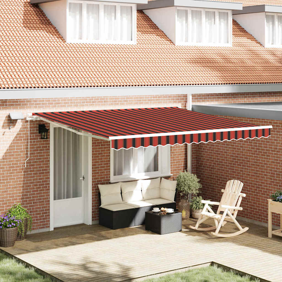 Eine Terrasse mit rot-schwarz gestreifter Markise, Sofa, Tisch, Schaukelstuhl und Pflanzen. Rote Backsteinmauer und Ziegeldach im Hintergrund.