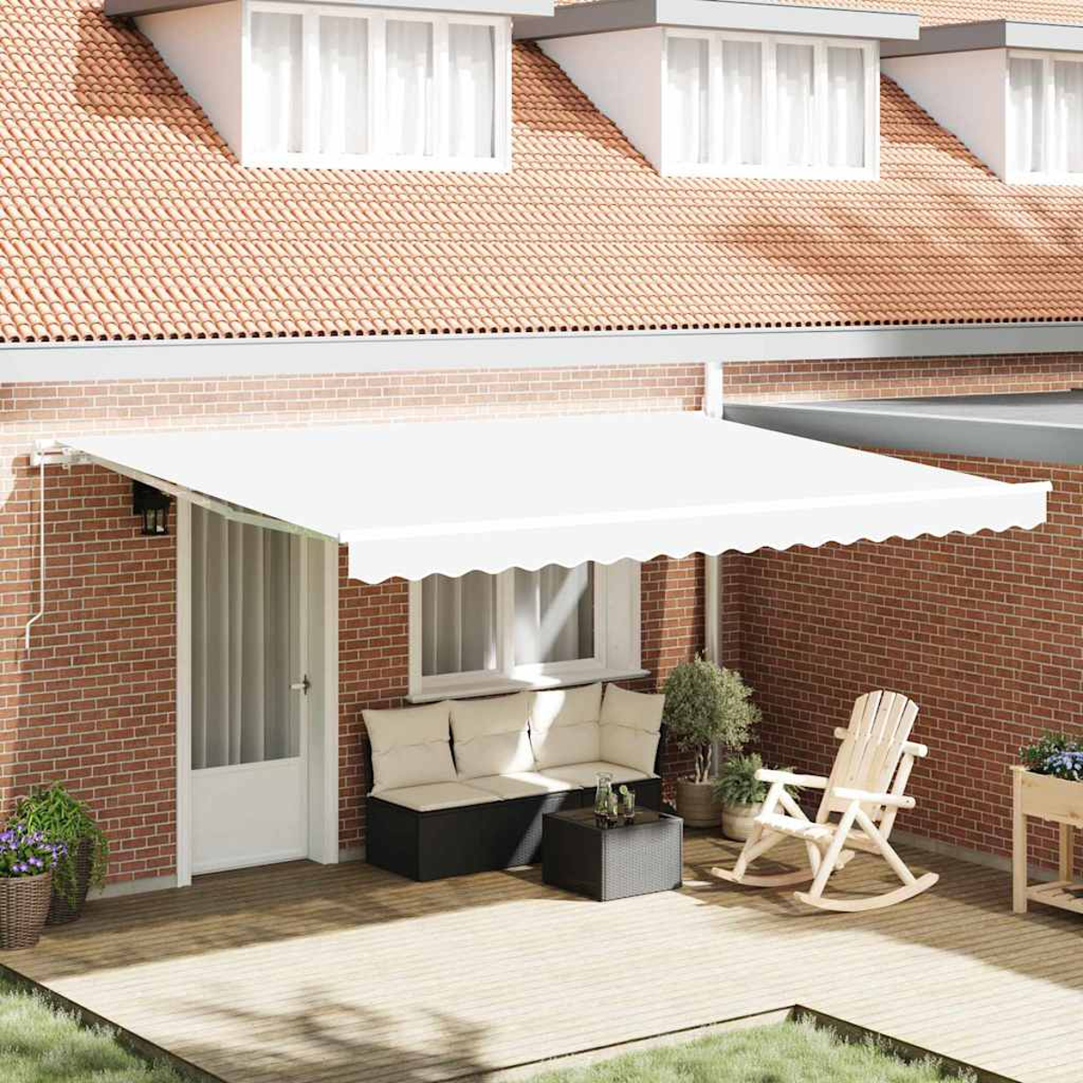 Eine weiße Markise bedeckt eine Terrasse mit Sofa, Tisch und Schaukelstuhl. Eine Ziegelmauer und ein rotes Dach sind sichtbar.
