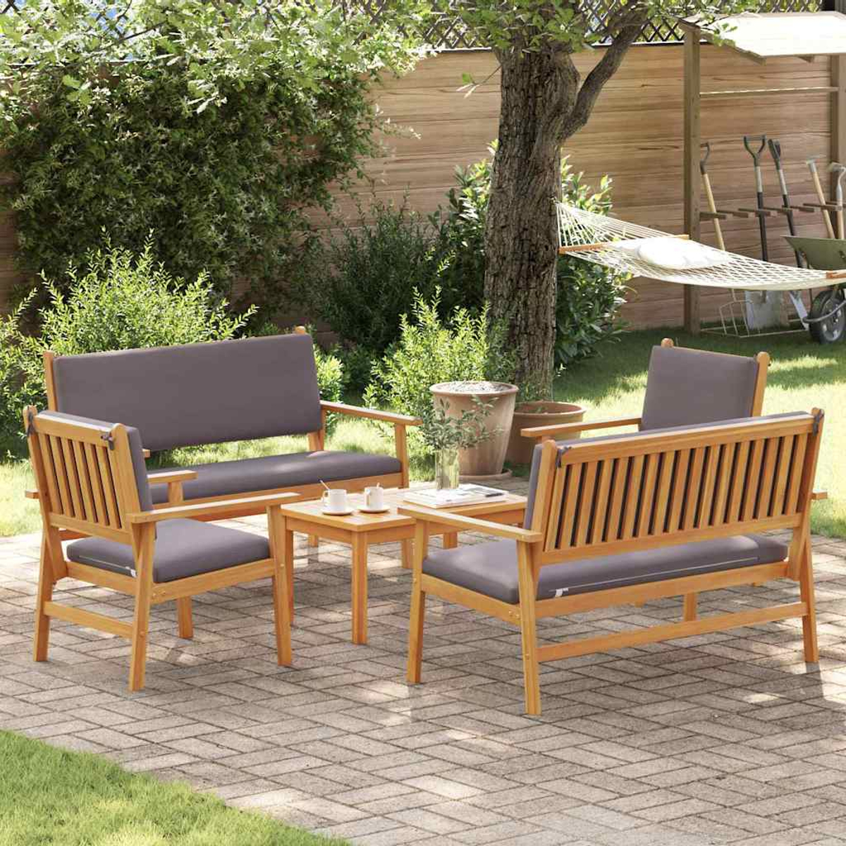 Gartensitzgruppe mit Holzbank, zwei Stühlen und einem kleinen Tisch. Graue Kissen. Hängematte im Hintergrund. Ziegelpflaster.