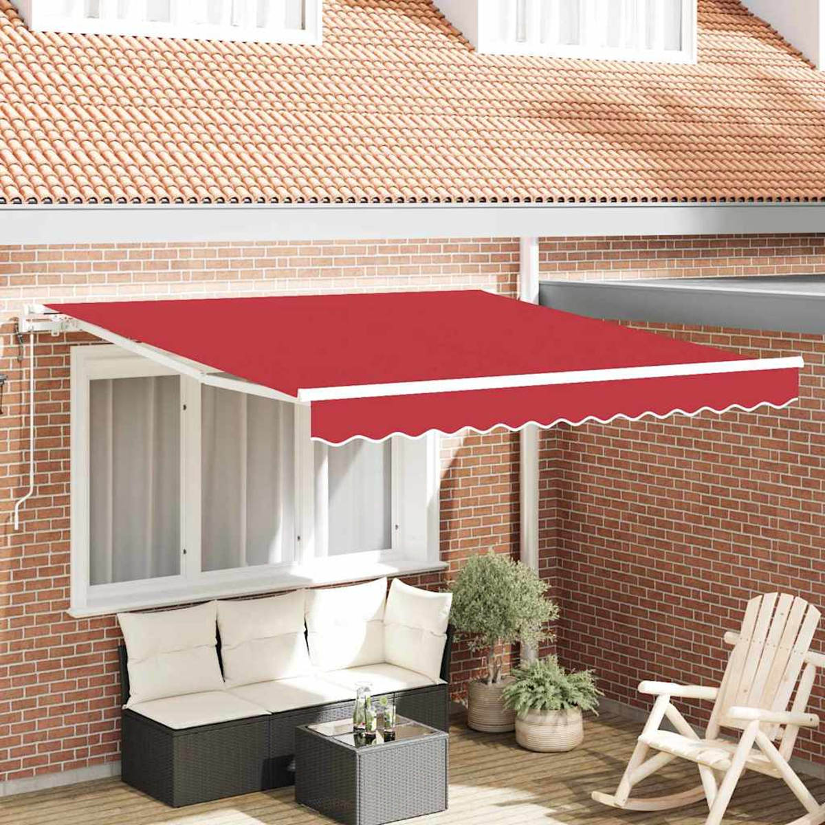 Ein roter Markisenüberhang über einem Fenster. Darunter ein schwarzes Korbmöbel und Tisch auf einer Holzterrasse. Eine Backsteinmauer und ein Ziegeldach.