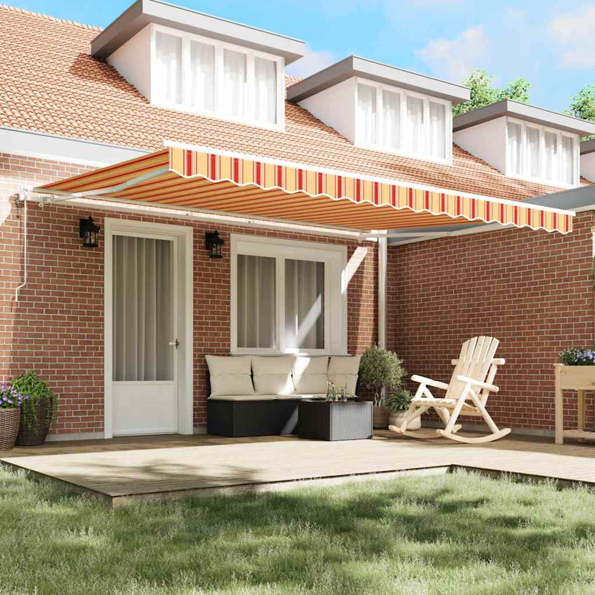Ein Haus mit roter Backsteinmauer. Eine gestreifte Markise bedeckt die Terrasse. Es gibt einen Schaukelstuhl und ein Sofa. Grünes Gras im Vordergrund.