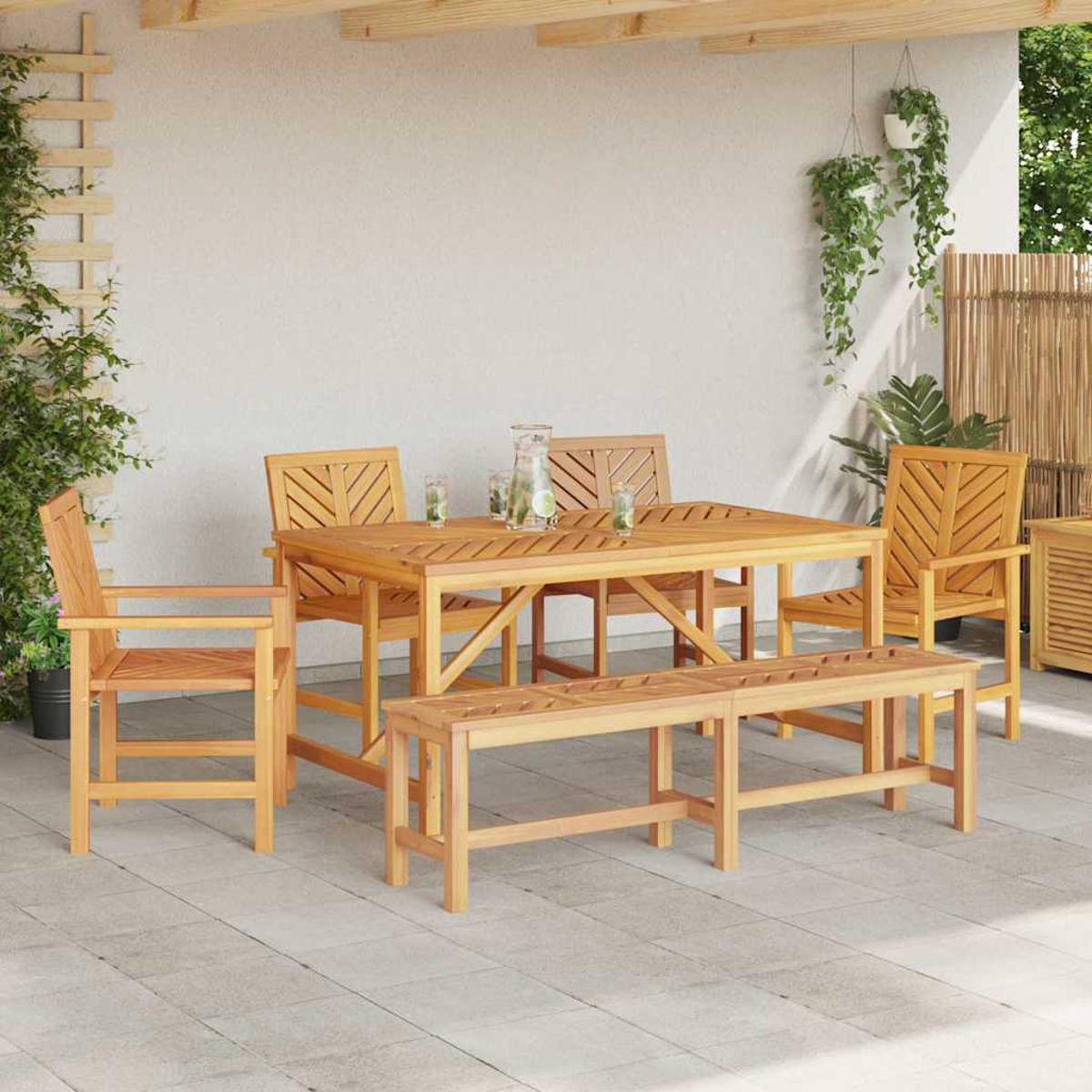 Essgruppe aus Holz im Freien mit Tisch, Stühlen und Bank. Auf einer gefliesten Terrasse. Grüne Pflanzen hängen im Hintergrund.