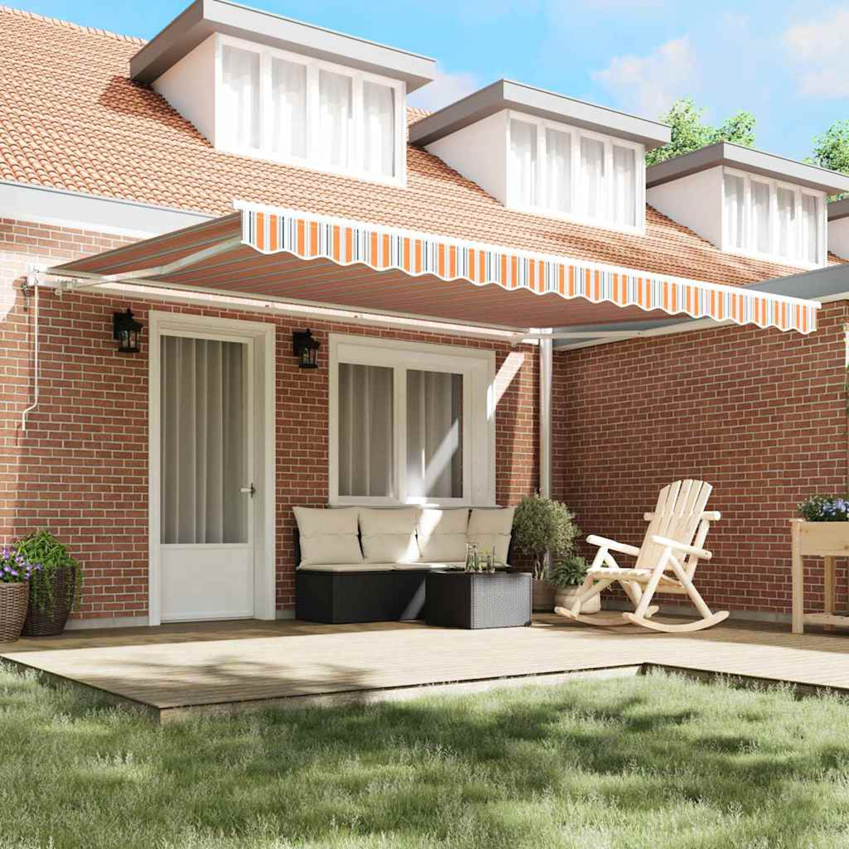 Ein Haus mit einem orange gestreiften Vordach. Eine Holzterrasse mit Schaukelstuhl und Sofa. Grünes Gras im Vordergrund.
