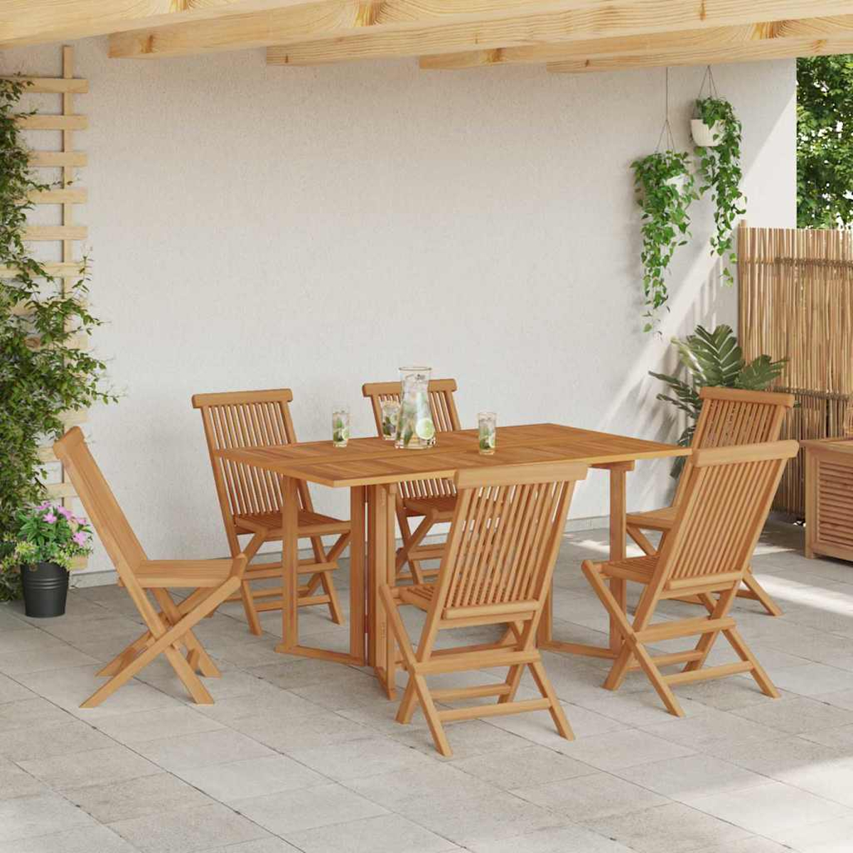 Essgruppe im Freien: Holztisch und Stühle auf einer Terrasse. Pflanzen und Gläser stehen auf dem Tisch. Sonnenlicht ist sichtbar.