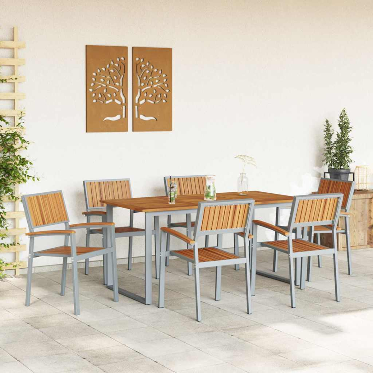 Essgruppe im Freien mit Holztisch und Stühlen. Zwei Wandkunstwerke mit Bäumen. Eine kleine Pflanze im Topf. Weißer Hintergrund.