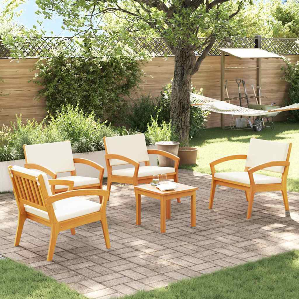 Szene im Freien mit Holzstühlen, einem kleinen Tisch und einer Hängematte. Die Stühle haben cremefarbene Kissen auf einer Ziegelterrasse.