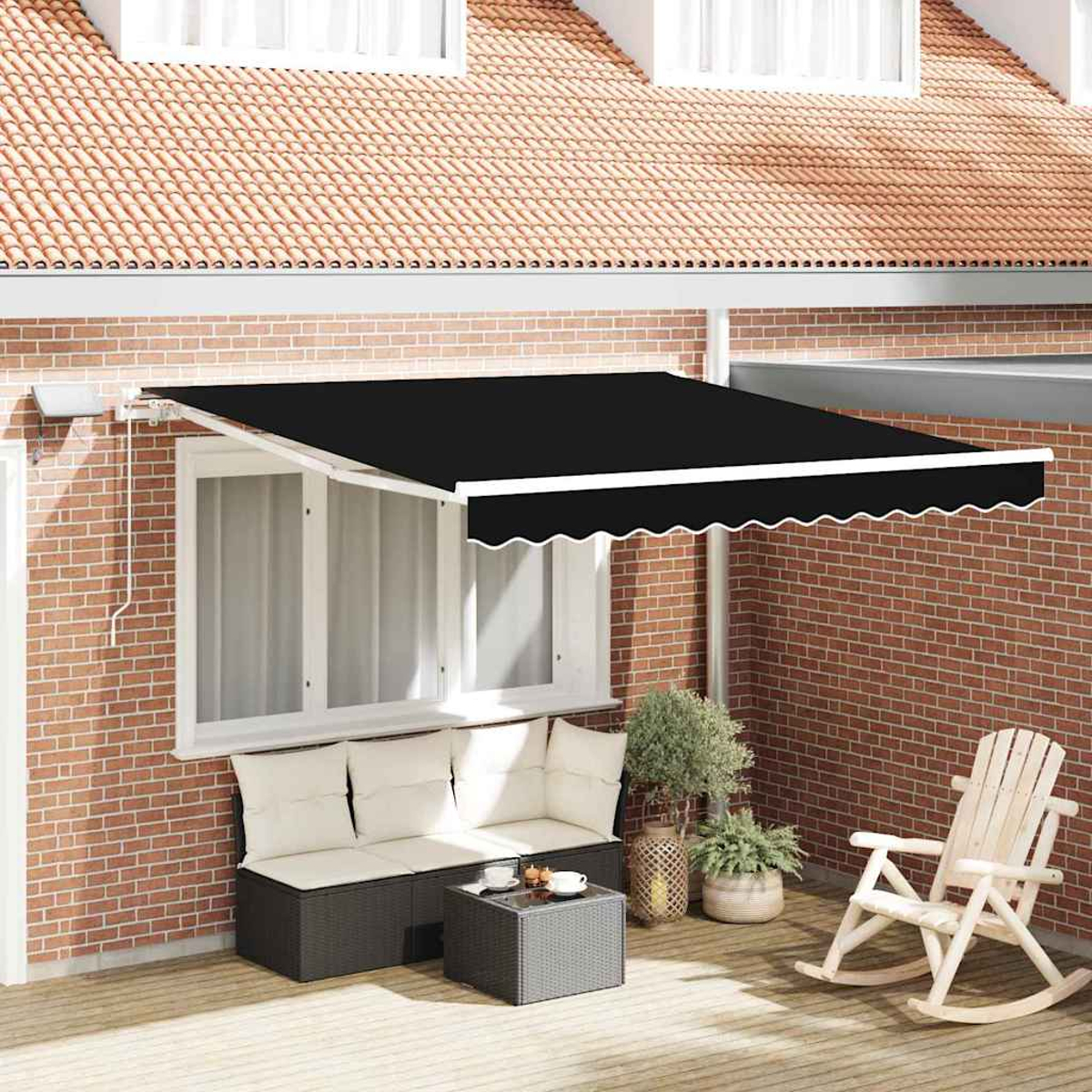 Eine schwarze Markise mit weißer Umrandung bedeckt eine Terrasse mit Sofa, Couchtisch, Schaukelstuhl und Pflanzen. Rote Backsteinmauer.