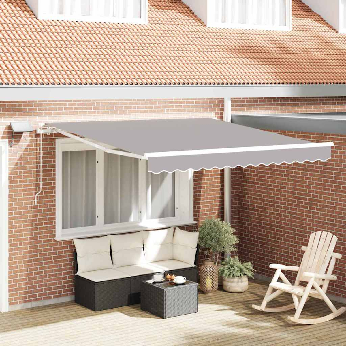 Ein grauer Sonnenschirm erstreckt sich über eine Terrasse mit Sofa, Tisch und Schaukelstuhl. Rote Backsteinmauer und Dach im Hintergrund.