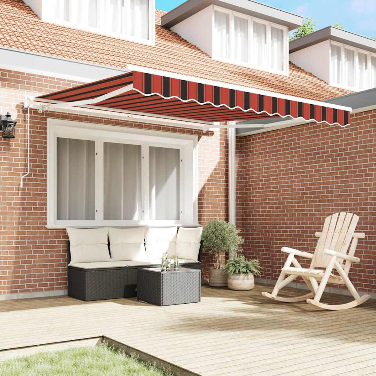 Eine Terrasse mit Markise, Sitzgelegenheiten und einem Schaukelstuhl. Die Markise hat rot-schwarze Streifen. Das Haus ist aus Ziegeln.