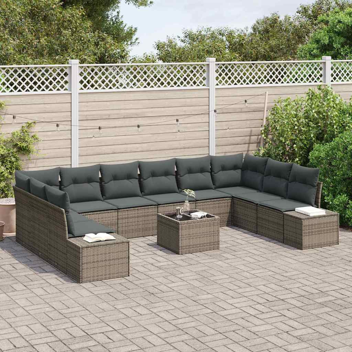 Outdoor-Ecksofa mit grauen Kissen auf einer Ziegelterrasse. Inklusive Couchtisch, vor einem weißen Zaun und üppigem grünen Hintergrund.