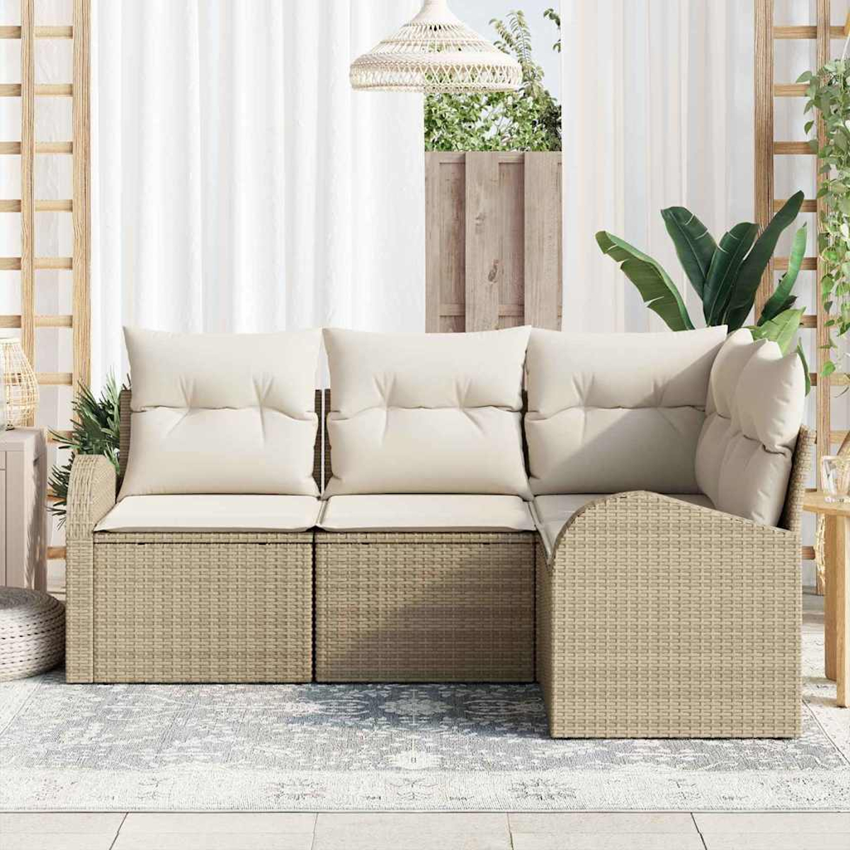 Beiges Rattan-Ecksofa mit cremefarbenen Kissen auf einem grauen Teppich. Dahinter befinden sich ein weißer Vorhang und ein Holzfenster.