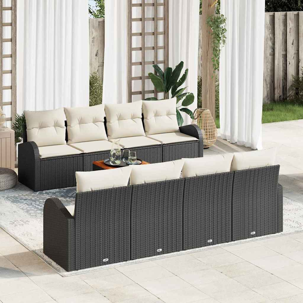Outdoor-Sitzbereich mit dunkelgrauen Korbsesseln, cremefarbenen Kissen und einem kleinen Tisch. Weiße Vorhänge und Grünzeug im Hintergrund.