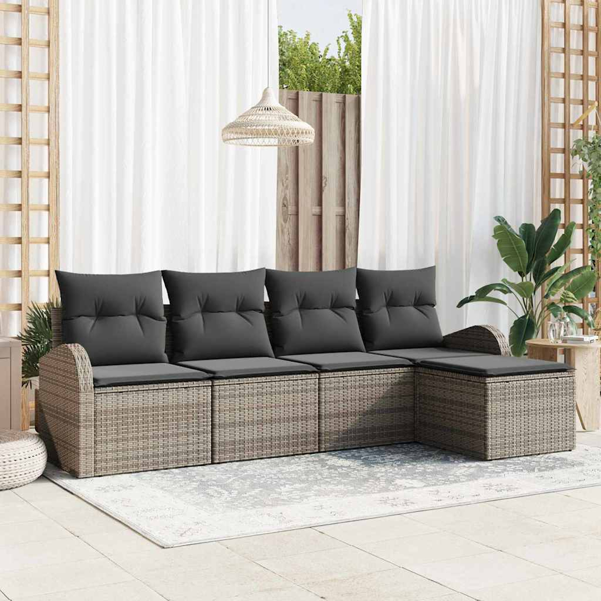 Outdoor-Rattansofa mit grauen Kissen. Weiße Vorhänge im Hintergrund. Eine Hängelampe und Pflanzen sind ebenfalls sichtbar.