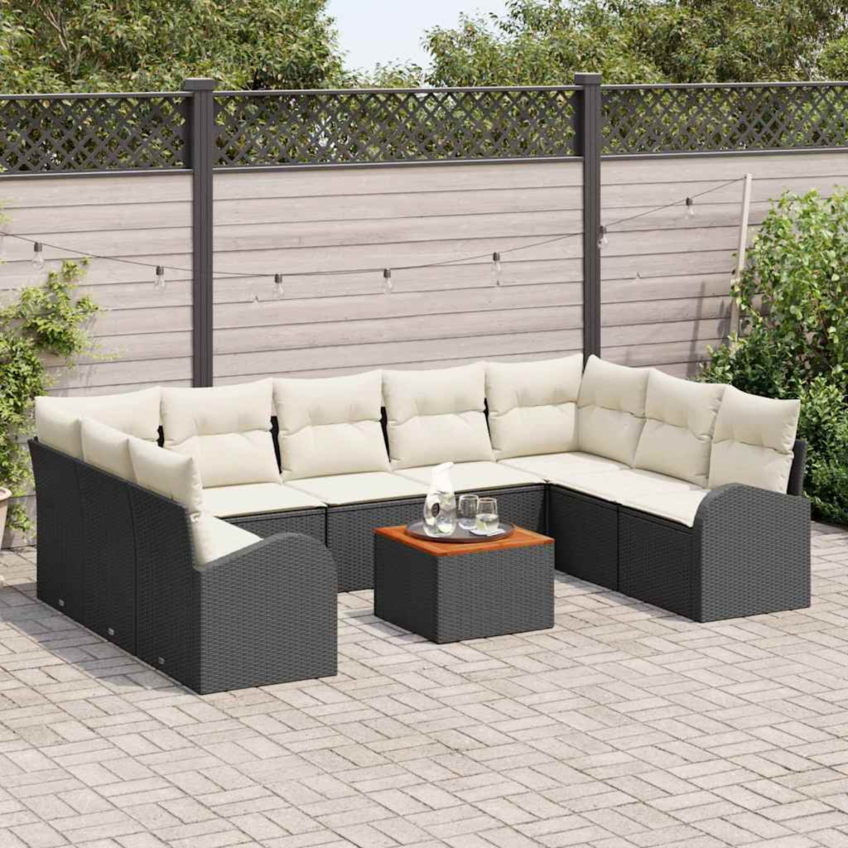 Ein Ecksofa im Freien mit cremefarbenen Kissen und einem kleinen Tisch mit Gläsern. Es steht auf einer Backstein-Terrasse vor einem Holzzaun.