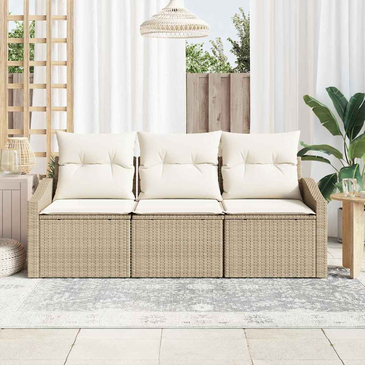 Ein beiges Rattan-Sofa mit weißen Kissen steht auf einem Teppich. Überkopf hängt eine gewebte Leuchte. Im Hintergrund sind Fenster und Pflanzen.