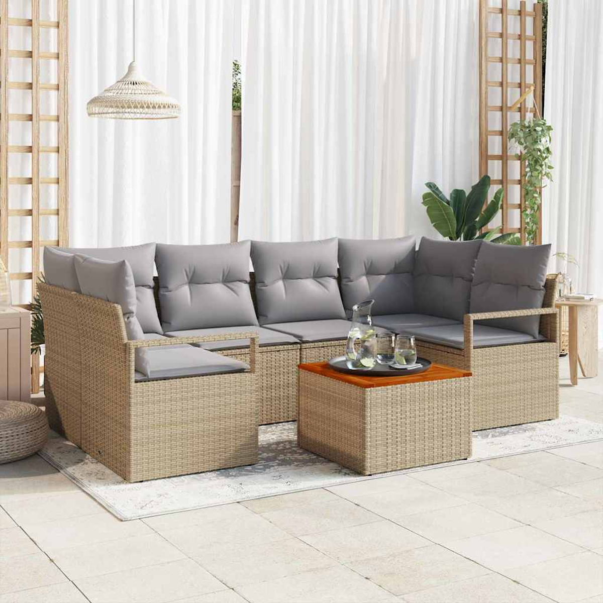 Ein beiges Korbsessel-Ecksofa mit grauen Kissen und einem Holztisch. Der Hintergrund hat weiße Vorhänge und Pflanzen.