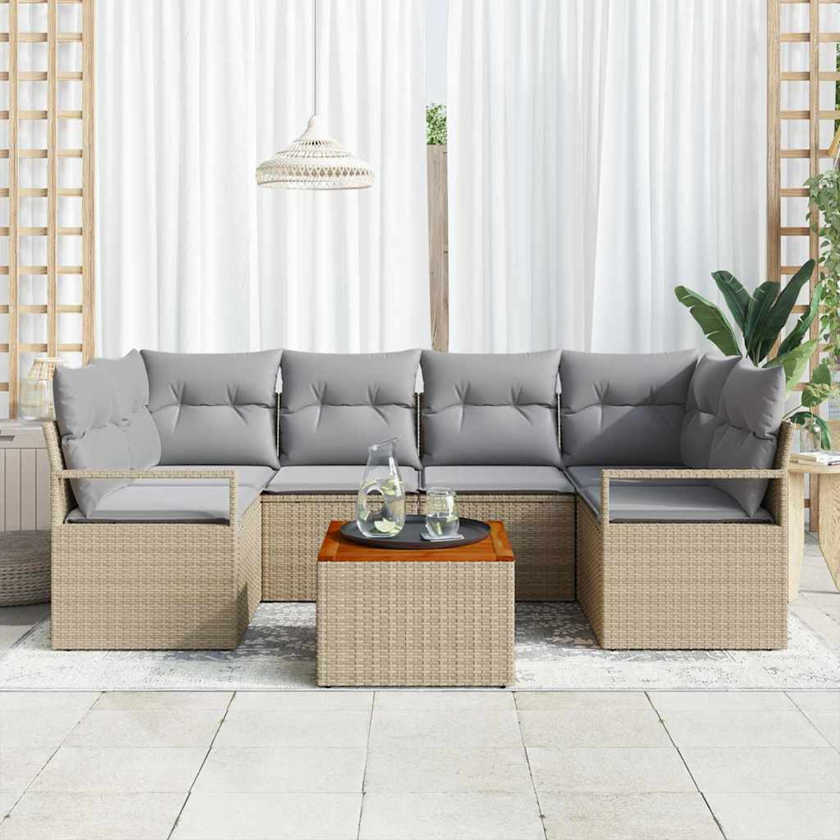 Ein Ecksofa im Freien mit grauen Kissen. Ein Holztisch trägt ein Tablett mit Getränken. Weiße Vorhänge sind im Hintergrund.