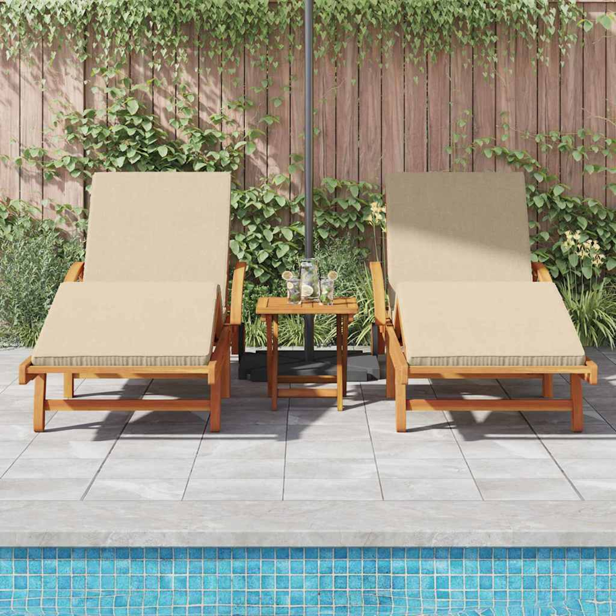 Zwei beige Liegestühle neben einem kleinen Tisch, in der Nähe eines Pools. Holzzaun und Laub im Hintergrund unter einem Sonnenschirm.