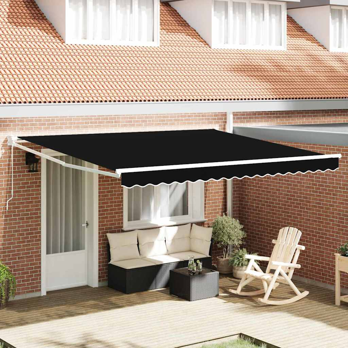 Ein schwarzes Vordach erstreckt sich über eine Terrasse. Darunter stehen Sofa, Tisch, Schaukelstuhl und Pflanzen auf Holzbohlen vor einer Backsteinmauer.