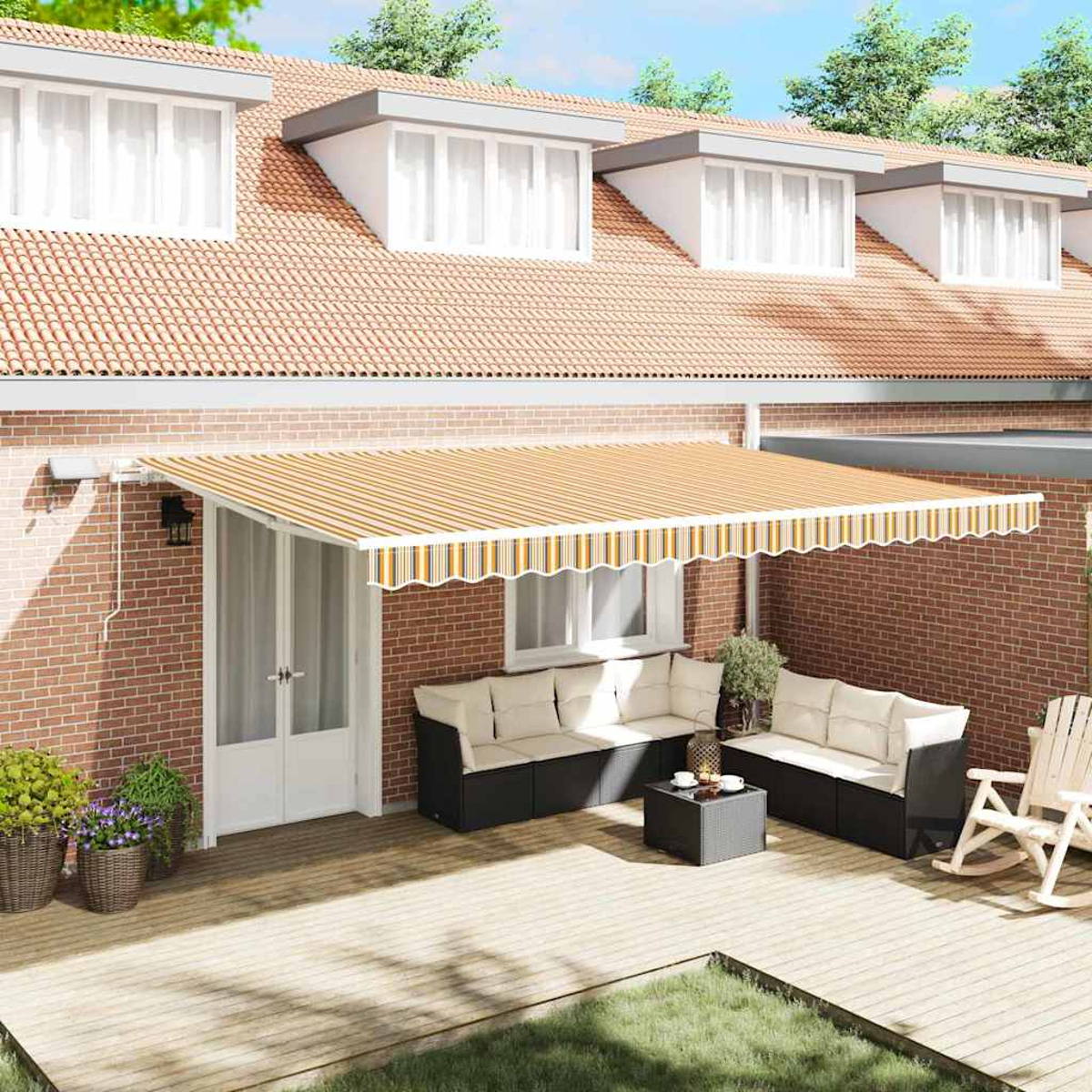 Eine Terrasse mit gestreifter Markise, Sitzgelegenheiten und einer roten Backsteinmauer. Im Hintergrund ein Haus mit Ziegeldach.