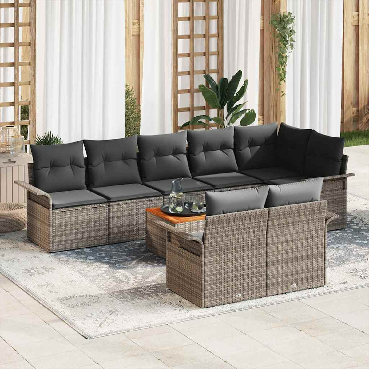 Outdoor-Wicker-Ecksofa mit grauen Kissen, Holztisch und passendem Loveseat auf einem gemusterten Teppich.
