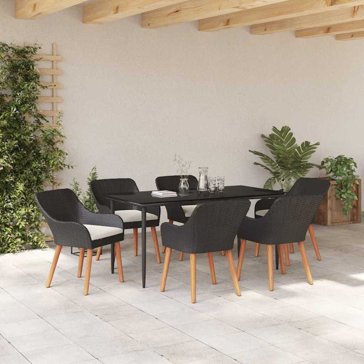 Essgruppe im Freien mit schwarzen Stühlen, einem schwarzen Tisch und Pflanzen im Hintergrund. Die Stühle haben hellfarbige Kissen und Holzbeine.