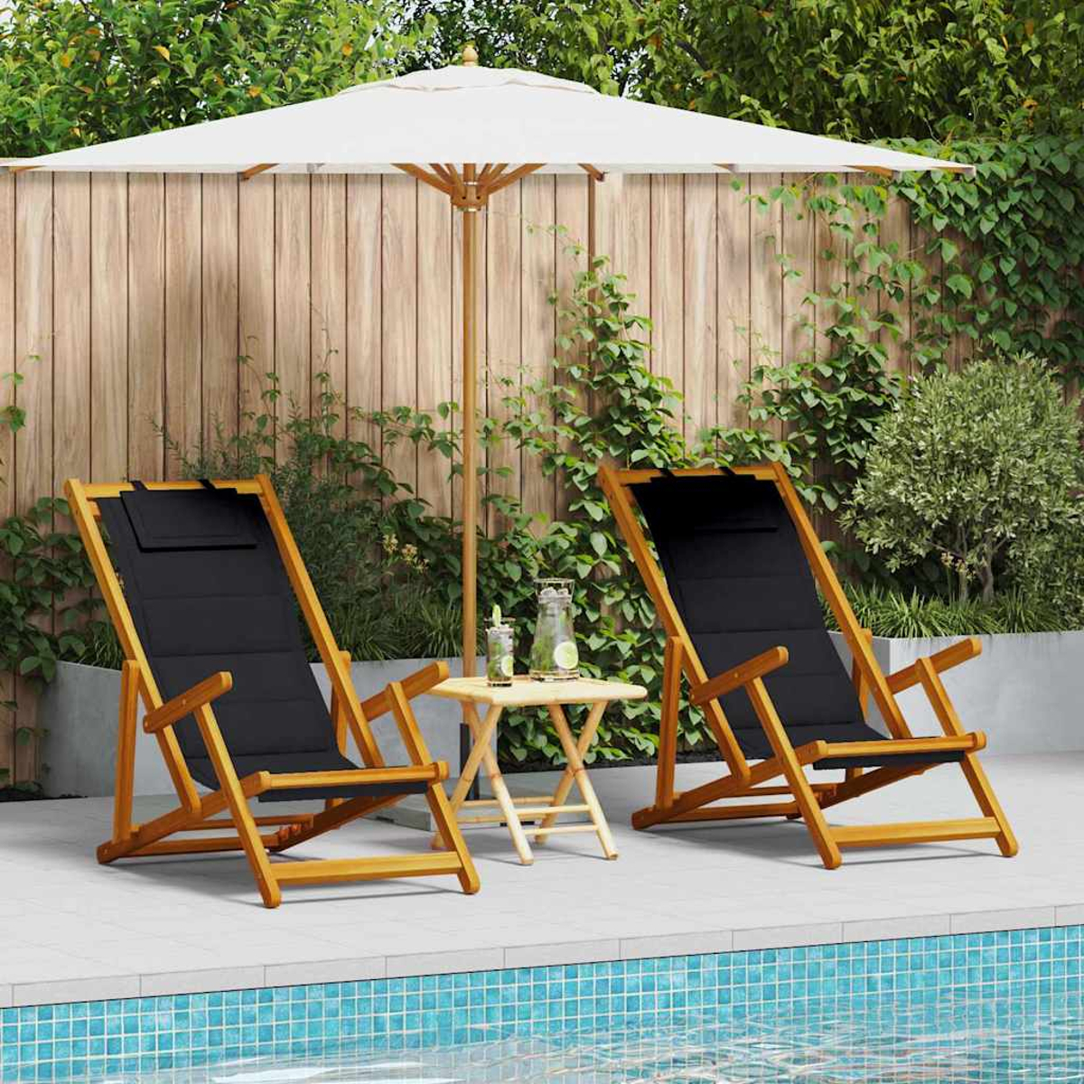 Zwei Holzliegen mit schwarzer Sitzfläche, ein kleiner Tisch und ein Sonnenschirm am Pool. Grüne Pflanzen und ein Holzzaun im Hintergrund.