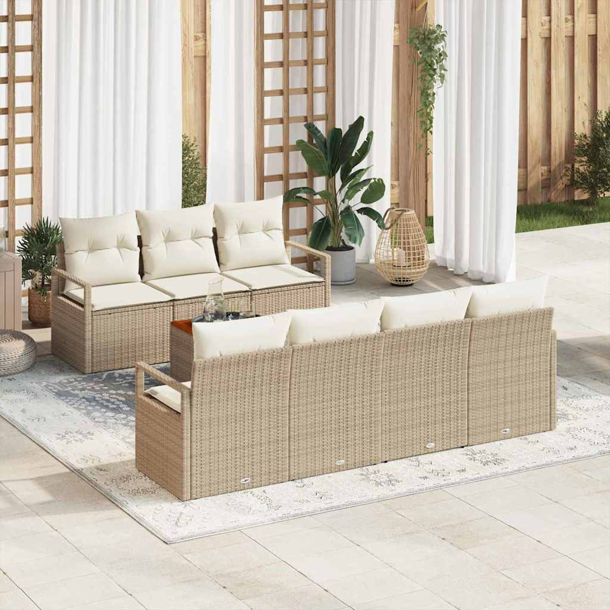 Szene im Freien mit Rattan-Sofas, weißen Kissen, Pflanzen und Vorhängen. Ein Teppich und ein Holzzaun befinden sich im Hintergrund.