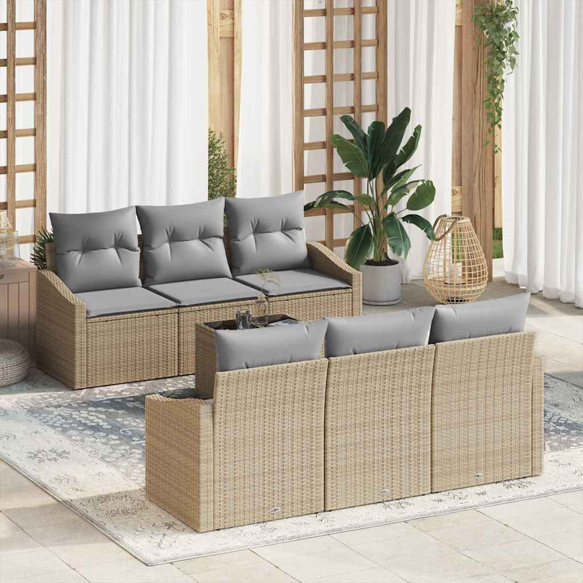 Gartenmöbel-Set aus Korbgeflecht mit grauen Kissen. Enthält ein Sofa, eine Couch und einen Couchtisch auf einer Terrasse mit Teppich und Pflanzen.