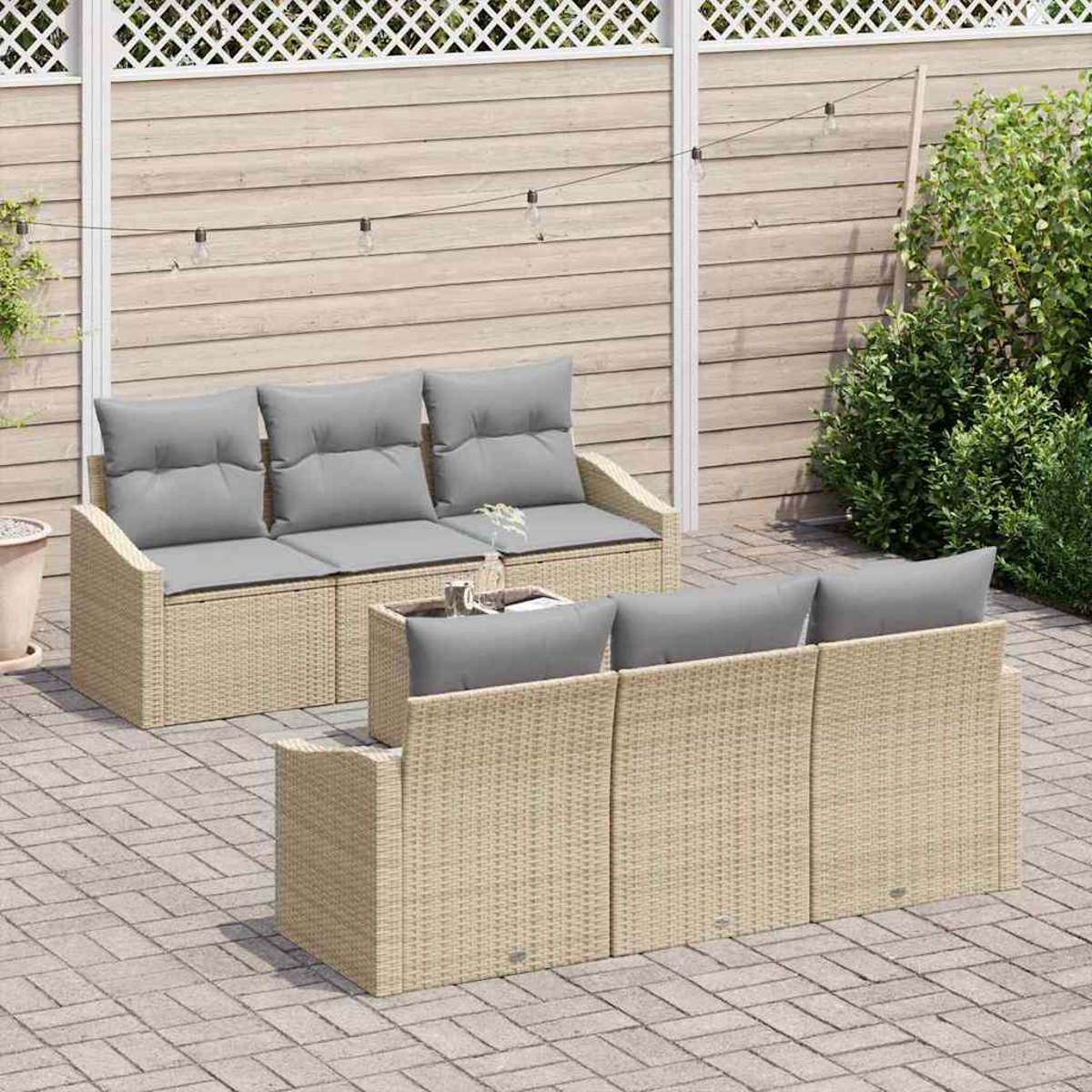 Garten-Terrassenset mit beigefarbenen Korbflechtrahmen und grauen Kissen. Das Set umfasst ein Sofa und zwei Stühle auf einer gepflasterten Terrasse.