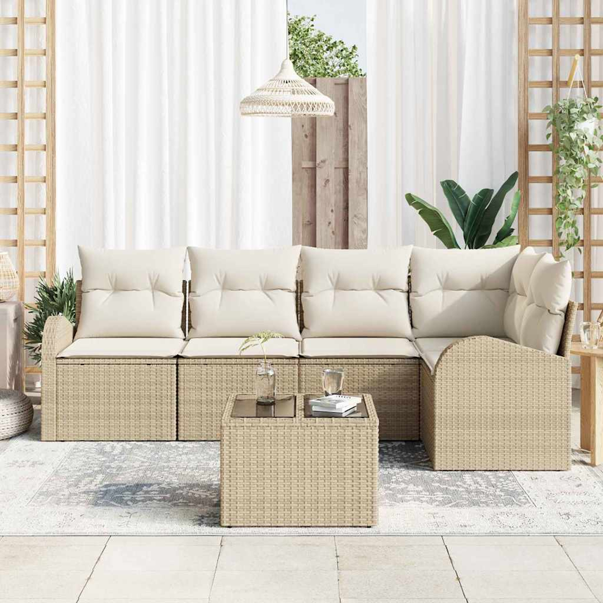Outdoor-Ecksofa mit cremefarbenen Kissen und einem Korbtisch auf einem gemusterten Teppich. Weiße Vorhänge und Pflanzen im Hintergrund.