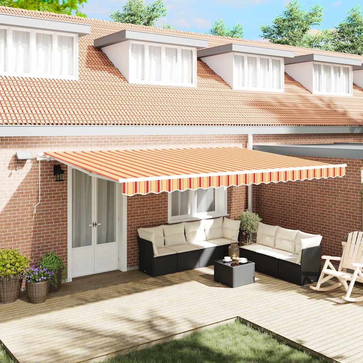 Hausfassade mit Terrasse. Mit Markise, Sofas und Tisch. Das Haus hat ein rotes Ziegeldach und Ziegelwände.