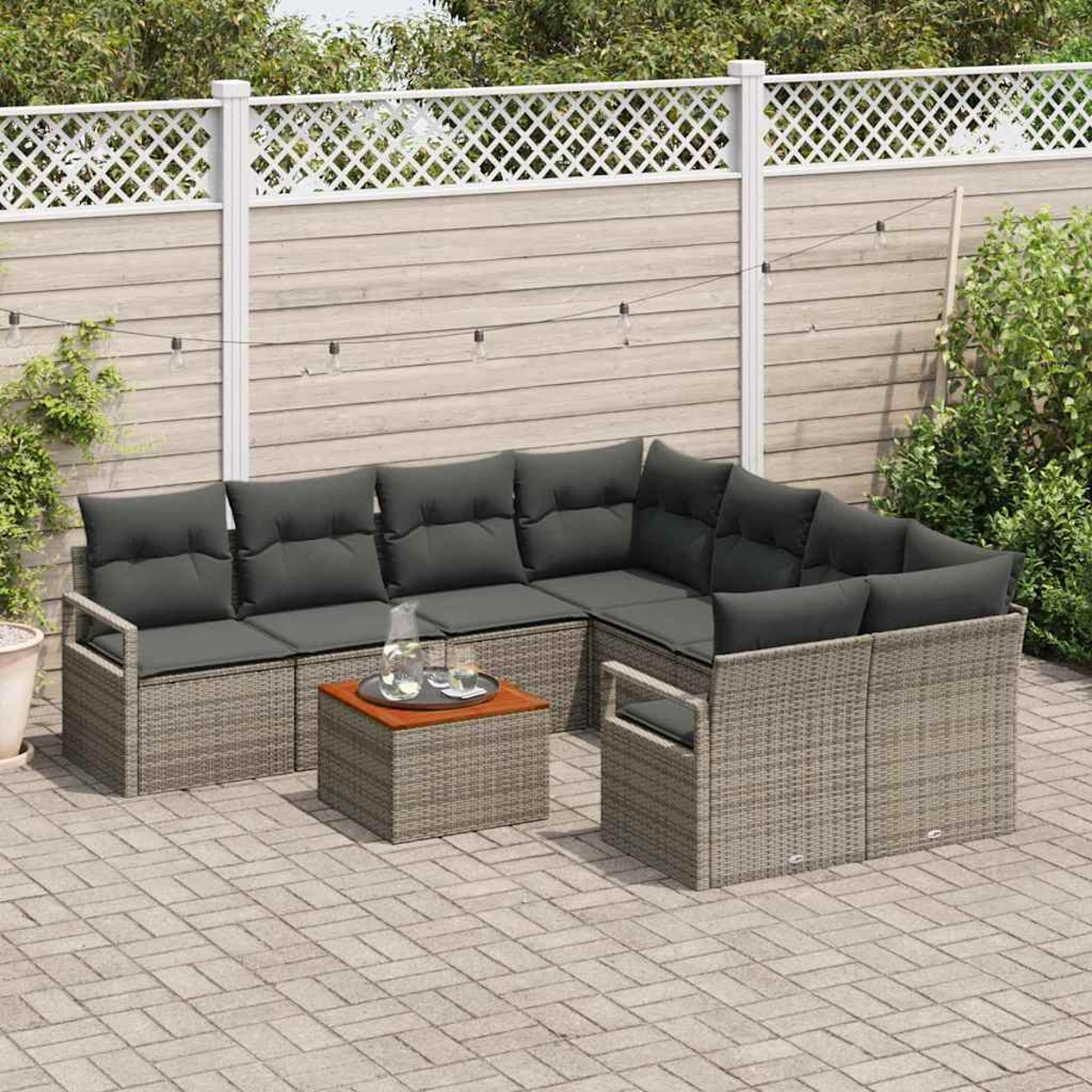 Outdoor-Sitzbereich mit grauen Kissen, Rattanmöbeln und einem kleinen Tisch. Auf einer Ziegelpflasterung, mit Holzzaun im Hintergrund.
