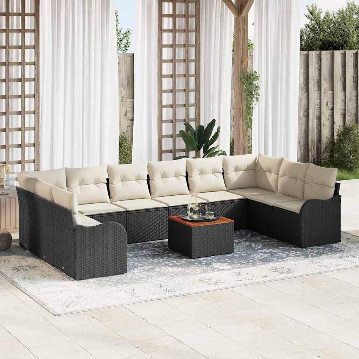 Outdoor-Ecksofa mit beigen Kissen, einem kleinen Tisch und einem Teppich. Weiße Vorhänge und ein Holzzaun im Hintergrund.
