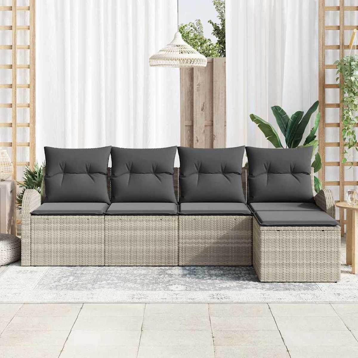 Outdoor-Korbmöbel mit grauen Kissen. Weiße Vorhänge im Hintergrund, eine Hängelampe und ein Teppich auf dem gefliesten Boden.