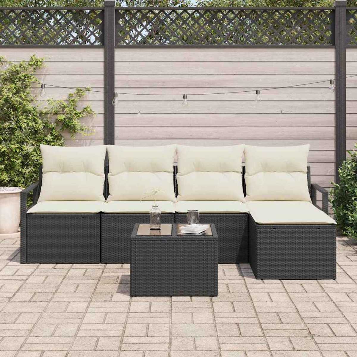Gartenmöbel-Set aus Korbgeflecht mit cremefarbenen Kissen. Enthält ein Sofa, einen kleinen Tisch und eine Backstein-Terrasse.