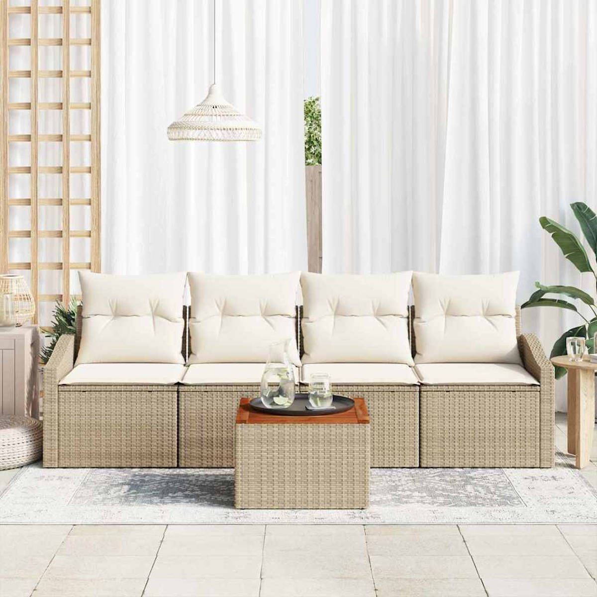 Ein Sitzbereich im Freien mit beigem Sofa, cremefarbenen Kissen und einem kleinen Tisch. Im Hintergrund ein weißer Vorhang, seitlich eine Pflanze.