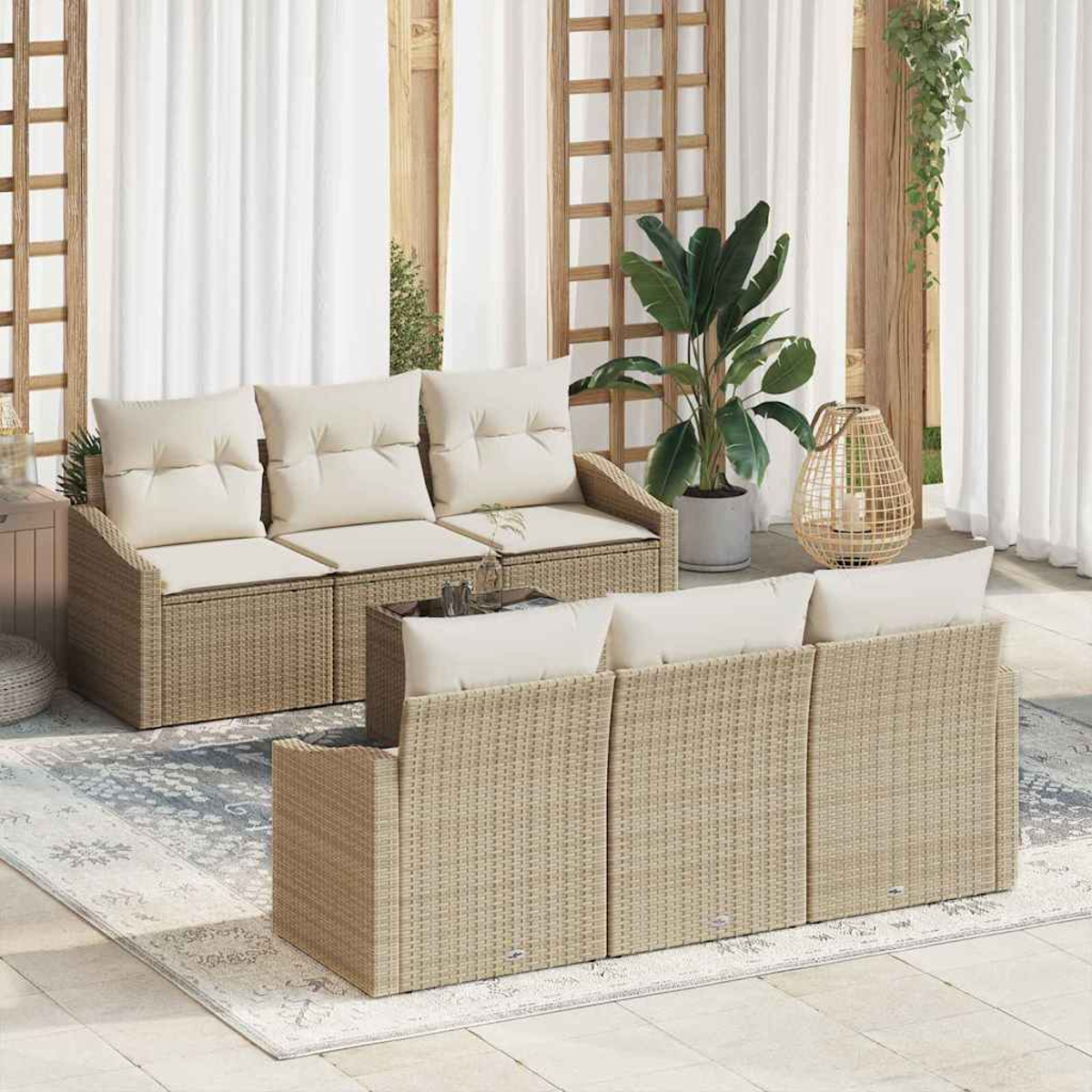 Gartenmöbel-Set. Beige Korbsessel mit cremefarbenen Kissen. Pflanzen, Teppich, weiße Vorhänge und Holzgitter im Hintergrund.