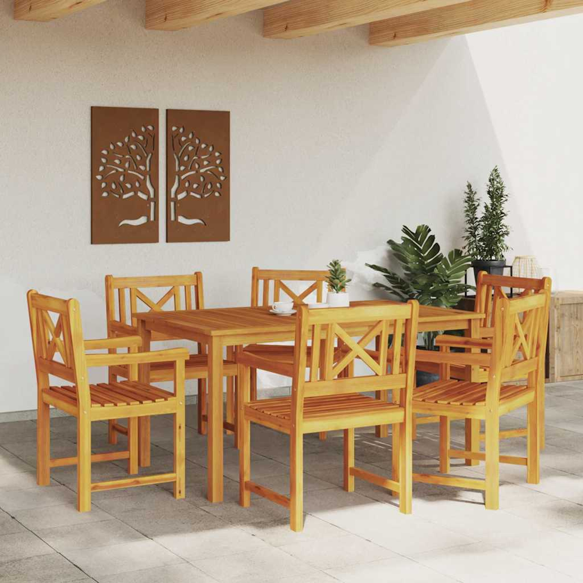 Essgruppe im Freien mit Holztisch und Stühlen. Zwei Wandkunstwerke und Pflanzen im Hintergrund.