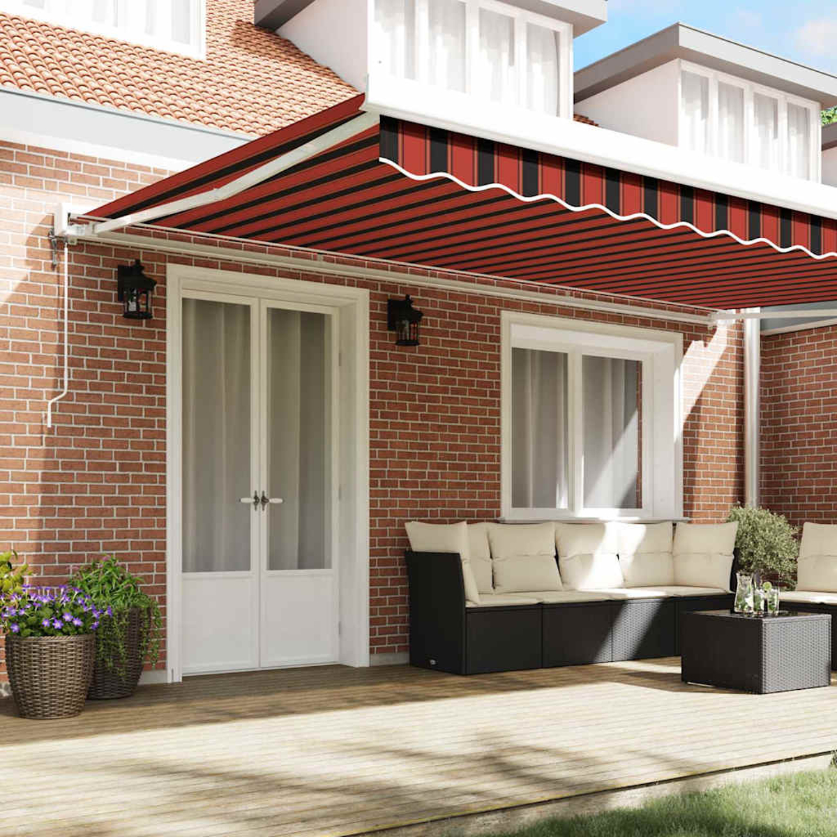 Eine rot-schwarz gestreifte Markise bedeckt eine Terrasse. Eine weiße Tür, Fenster und ein schwarzes Sofa sind sichtbar. Ziegelmauer und Pflanzen.