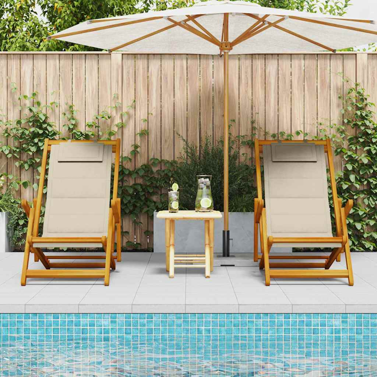 Dos sillas beige y una mesa pequeña con bebidas bajo una sombrilla blanca junto a una piscina.