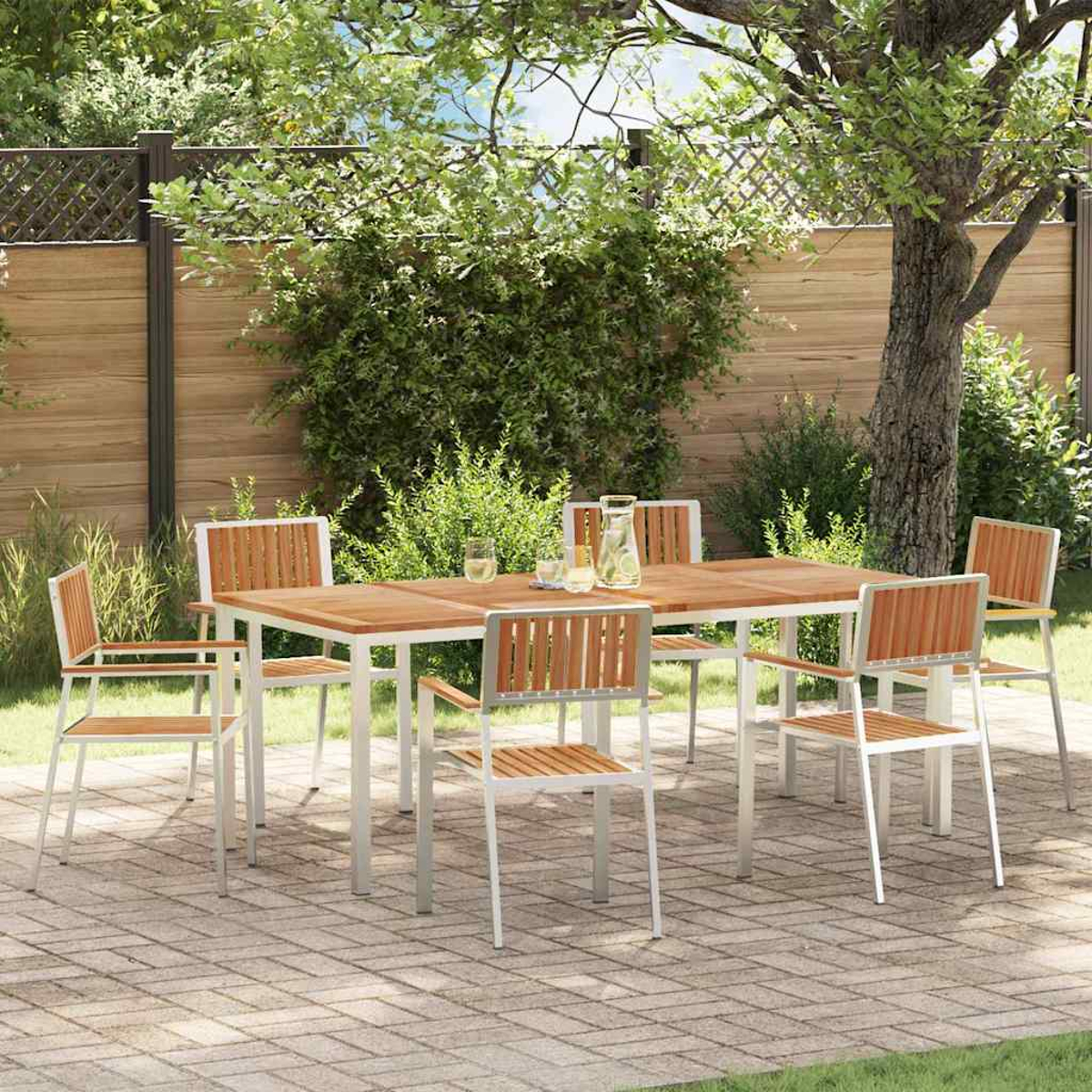 Essgruppe im Freien auf einer Ziegelterrasse. Holztisch und Stühle mit Metallrahmen, umgeben von Bäumen und Grün.