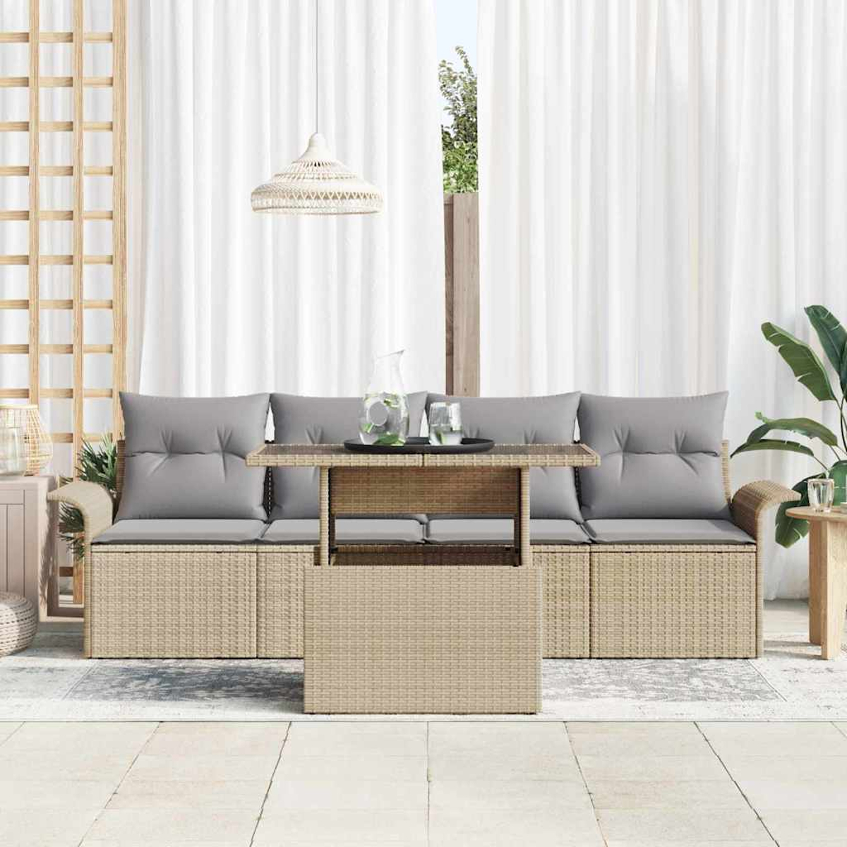 Gartenmöbel mit einem Rattansofa und -tisch. Graue Kissen, weiße Vorhänge und eine Hängelampe sind im Hintergrund zu sehen.