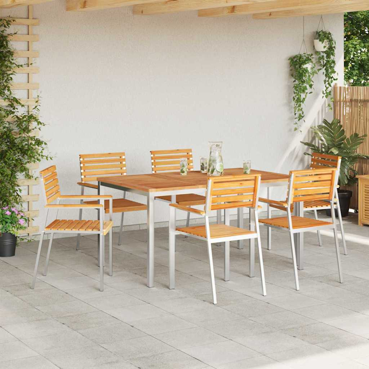 Juego de comedor al aire libre: mesa y sillas de madera en un patio. Plantas en macetas y cestas colgantes, luz brillante.
