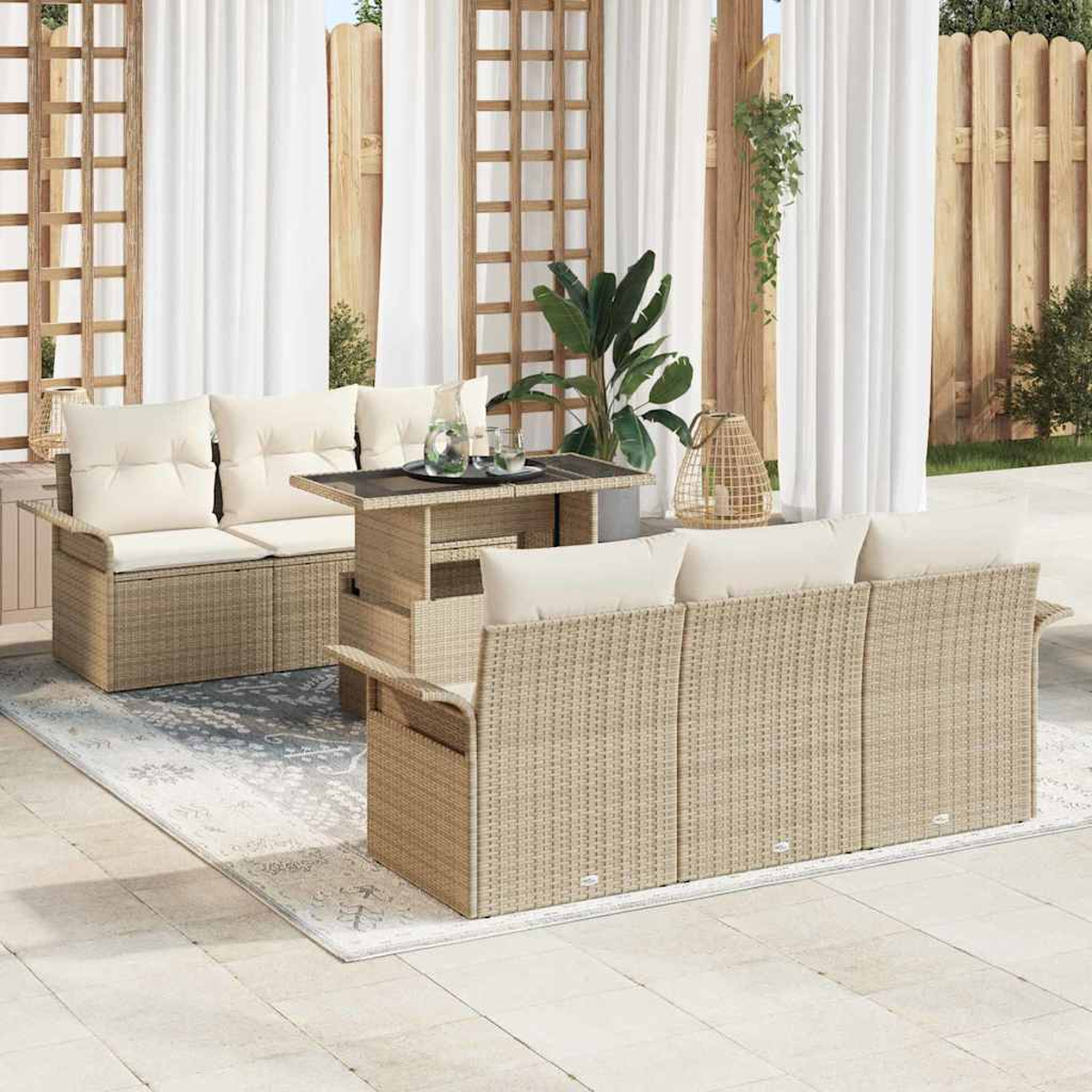 Juego de muebles de exterior en el patio. Sofás de mimbre beige, mesa y alfombra. Cortinas blancas y valla de madera.