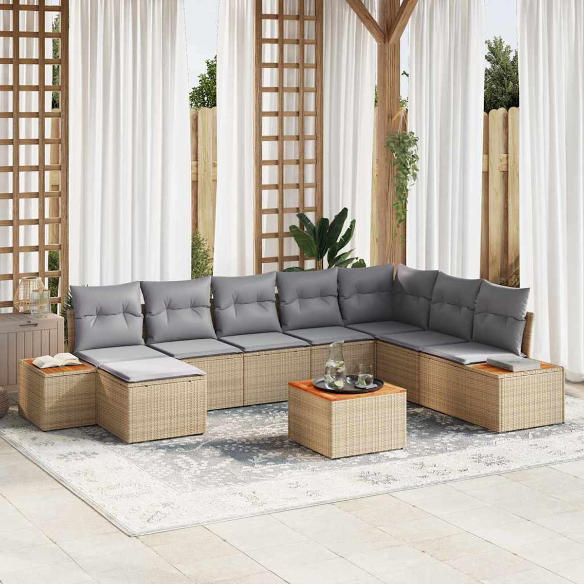 Sofá seccional exterior con cojines grises, base de mimbre y mesa pequeña. Cortinas blancas y pérgola de madera al fondo.
