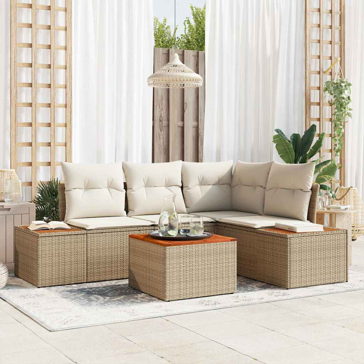 Rattan-Sofa im Freien mit cremefarbenen Kissen, einem Holztisch und weißen Vorhängen im Hintergrund, die eine gemütliche Atmosphäre schaffen.